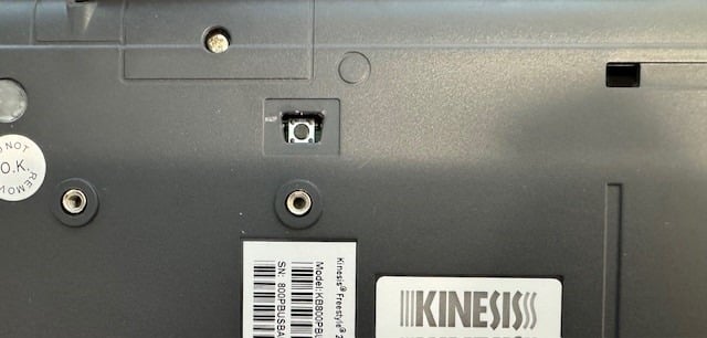 Close-up of a Kinesis keyboard model Freestyle2 bottom, showing the reset button and serial number label.