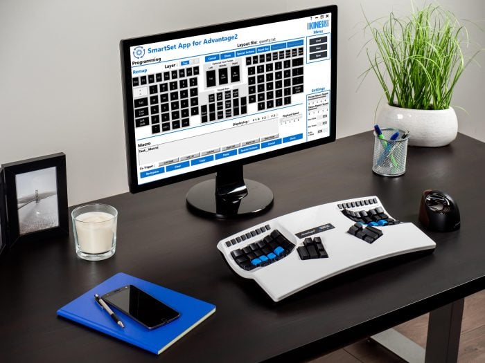 Ergonomic keyboard setup with SmartSet software on monitor, modern desk workspace, and accessories for productivity.