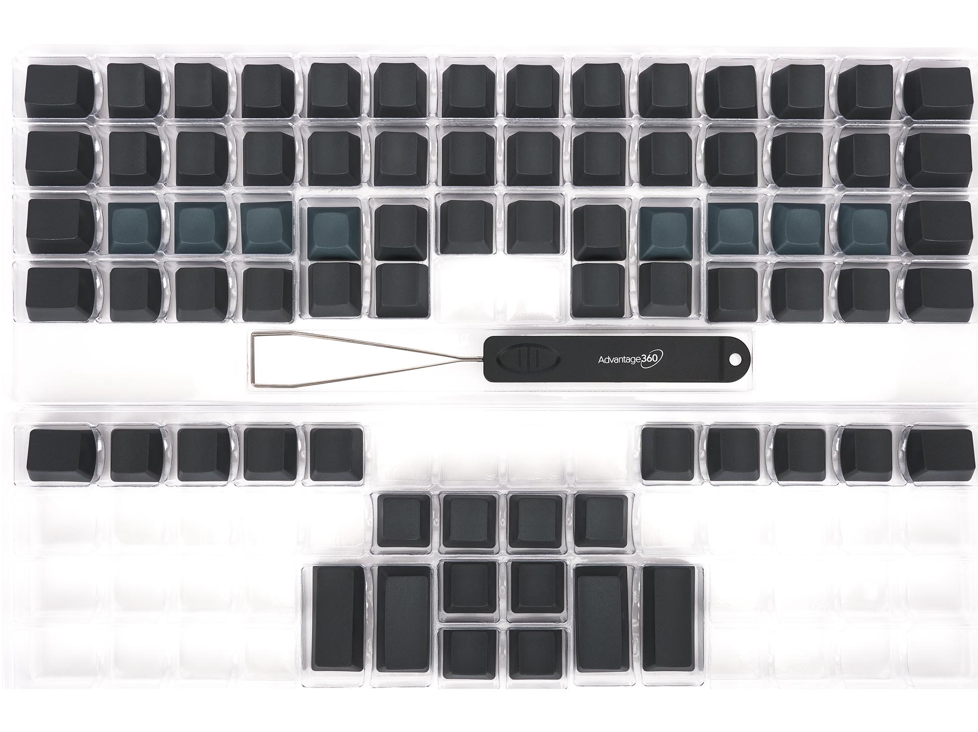 Ergonomic keyboard keycaps with Advantage 360 tool. Black keycaps arranged neatly on a transparent tray.