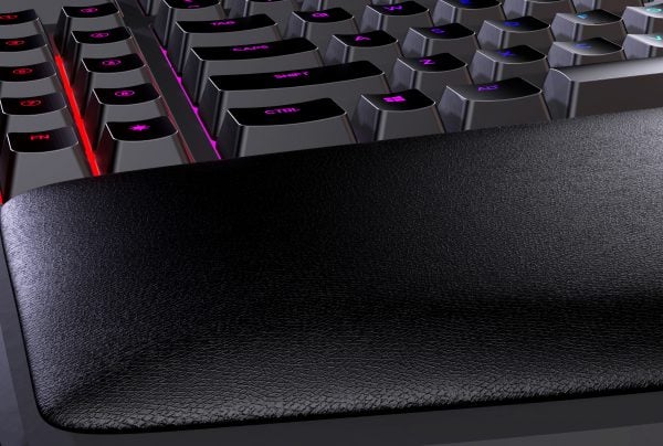 Close-up of an RGB mechanical keyboard with wrist rest, featuring illuminated keys and sleek design for gaming.