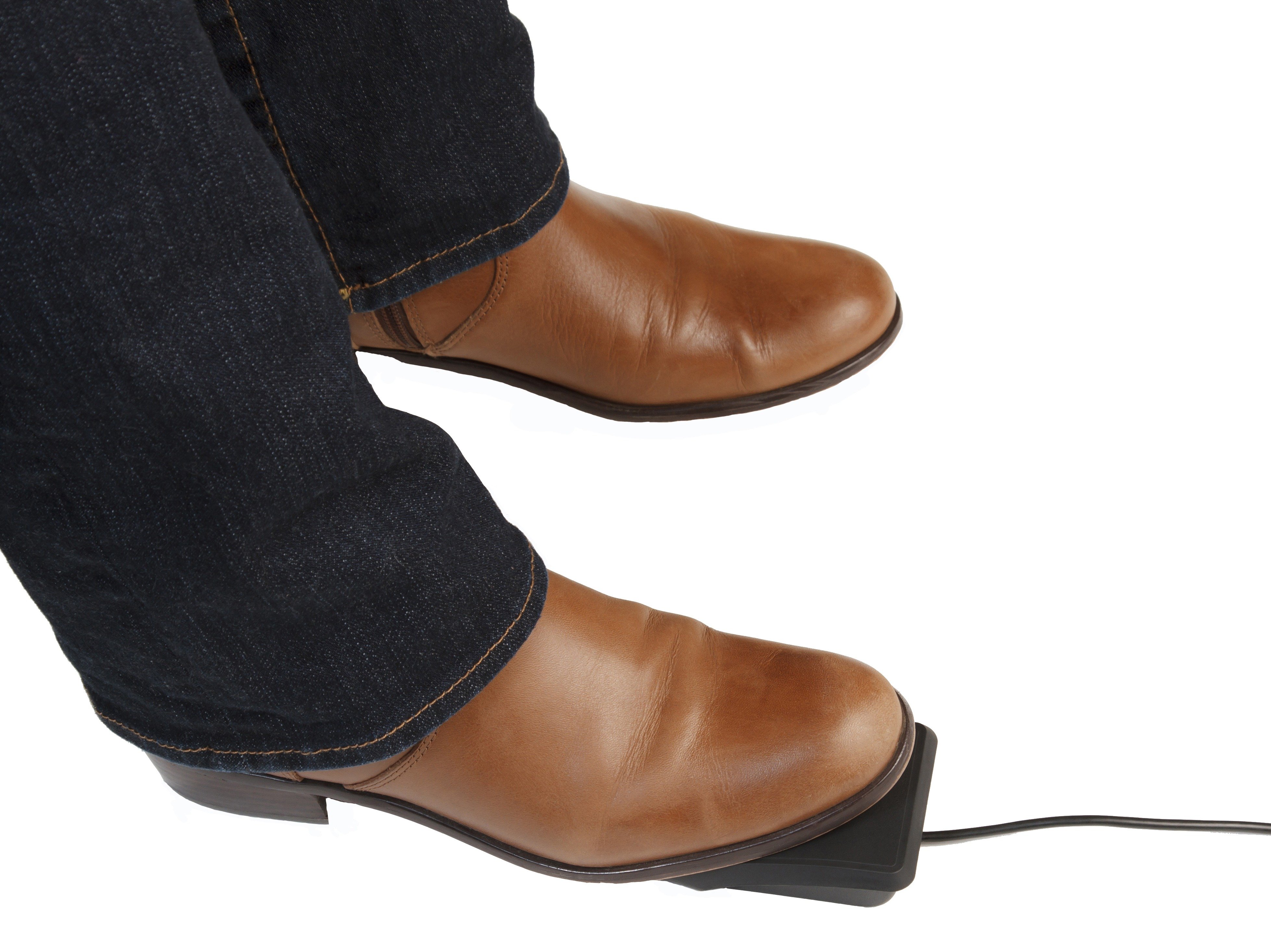 Brown shoes stepping on a black foot pedal switch, connected by a cable, on a white background.