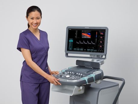 Healthcare professional using a modern ultrasound machine for medical imaging in a clinical setting.