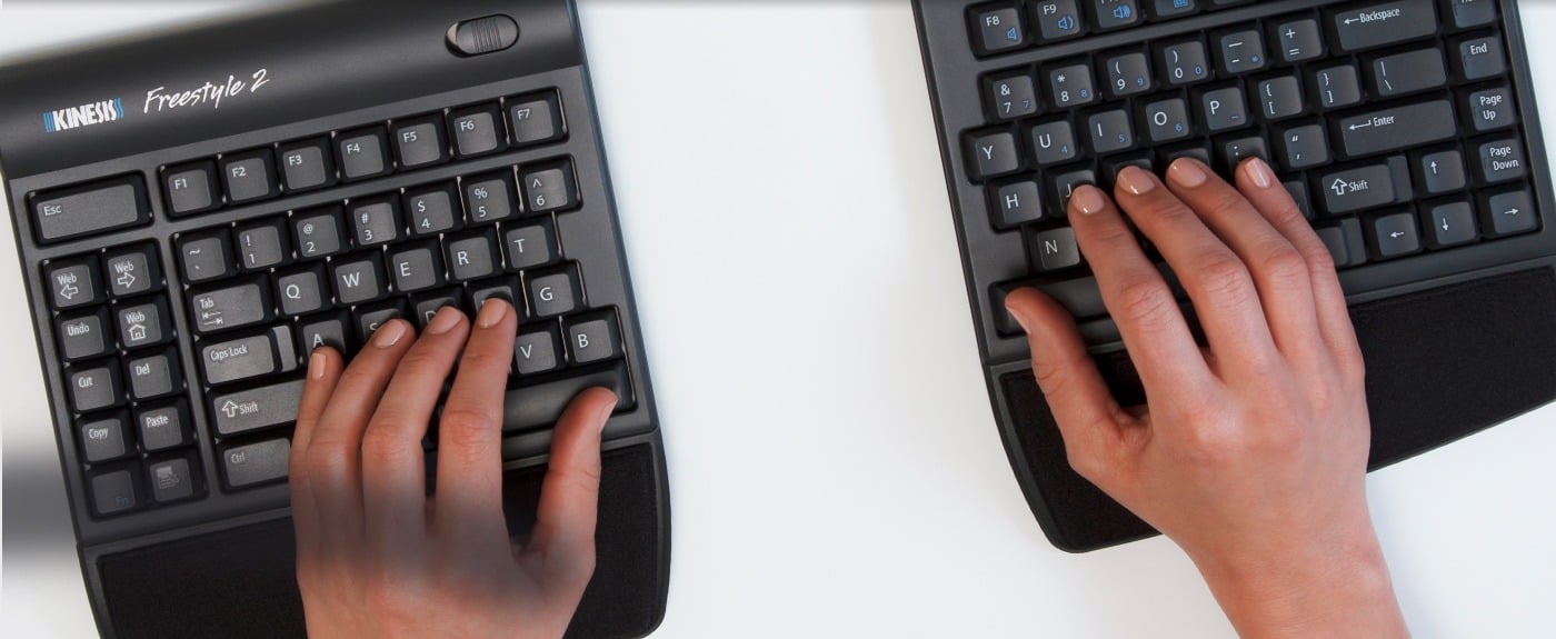 Hands typing on a split ergonomic keyboard for comfortable computer use.