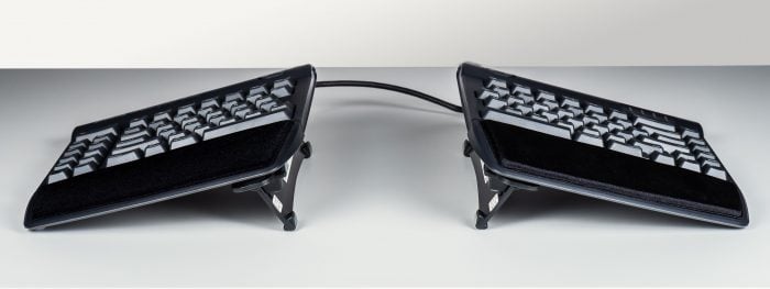 Ergonomic split keyboard on a desk, enhanced for comfort and adjustable typing position. Ideal for office setups.