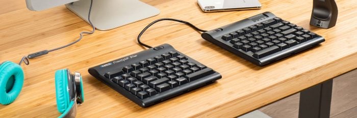 Ergonomic split keyboard on a wooden desk setup, enhancing comfort and productivity for computer users.